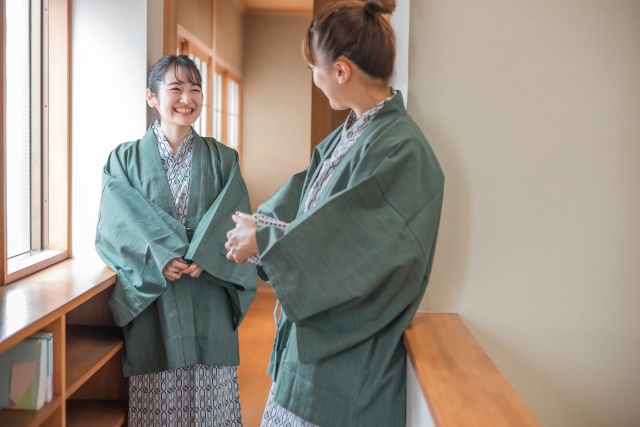 旅館で浴衣をきて談笑する女性2人