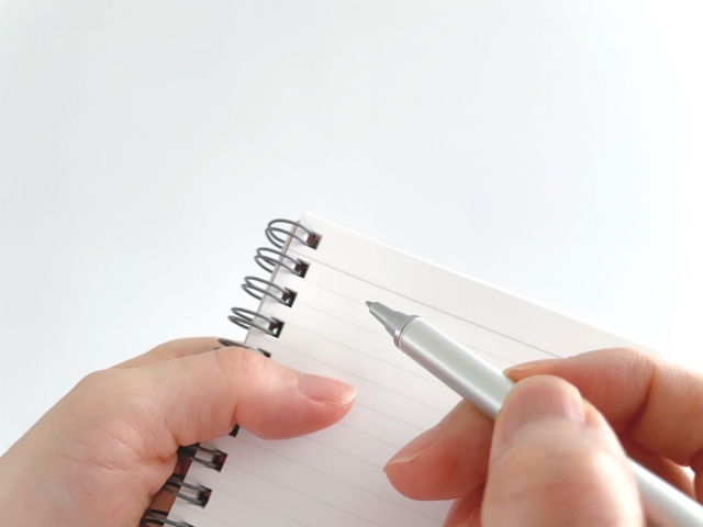 ノートに目もする女性の手