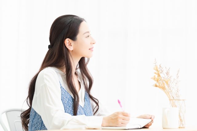 ノートに書きこむ女性