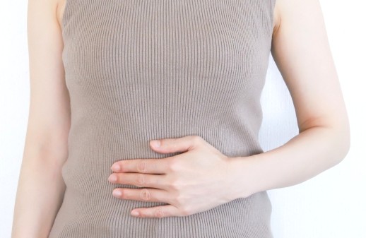 お腹に手を当てる女性