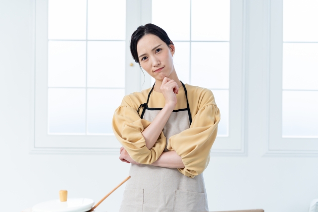 エプロンをして悩む女性