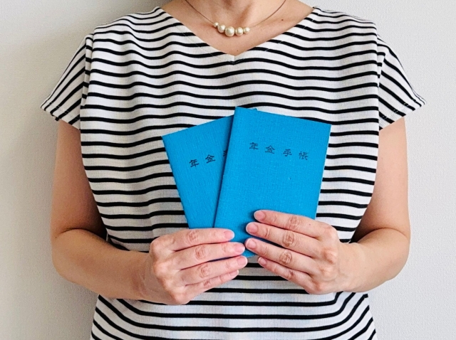 年金手帳を持つ女性の手