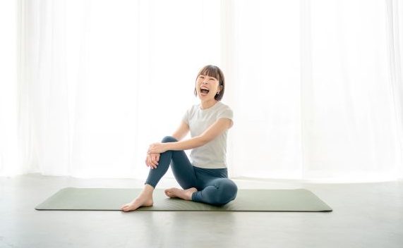ヨガマットに座る女性