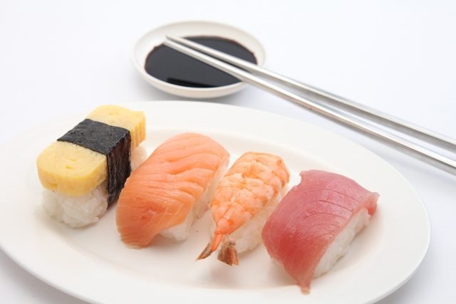 寿司と醤油皿に乗せた箸