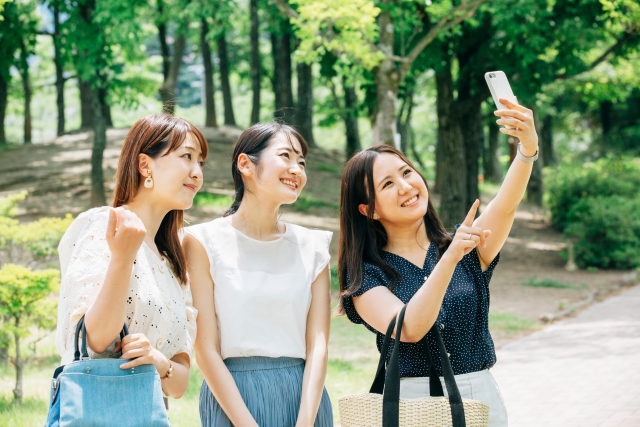 3人並んで写真を撮る女性