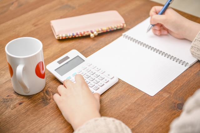 電卓気で計算している女性