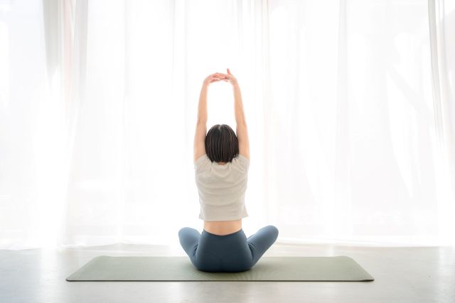 ヨガをする女性の後ろ姿