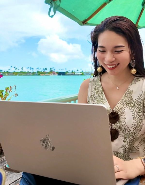 海辺でパソコンを使う女性