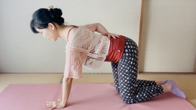 右手を背中に当てる