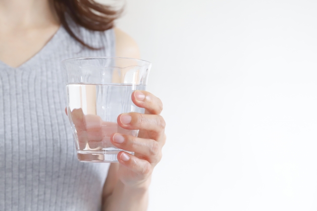 水の入ったコップを持つ女性